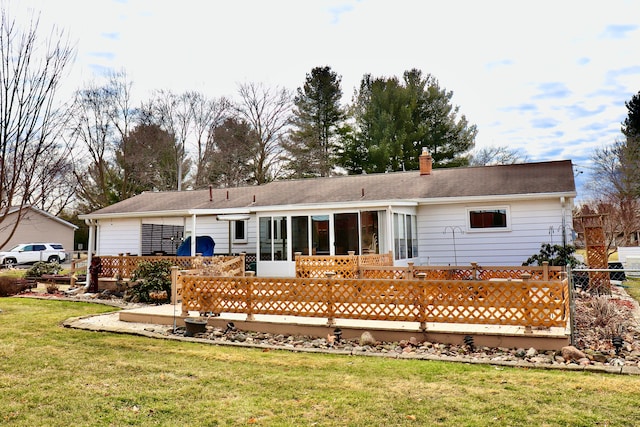 back of property featuring a sunroom, a lawn, a chimney, and fence