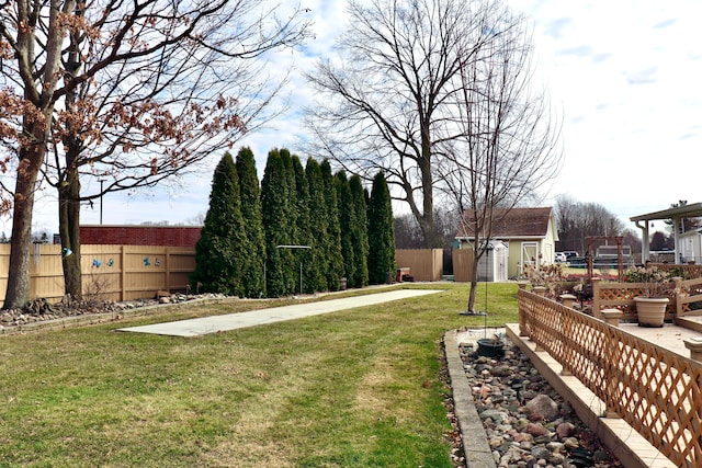 view of yard with an outbuilding, a fenced backyard, and a shed