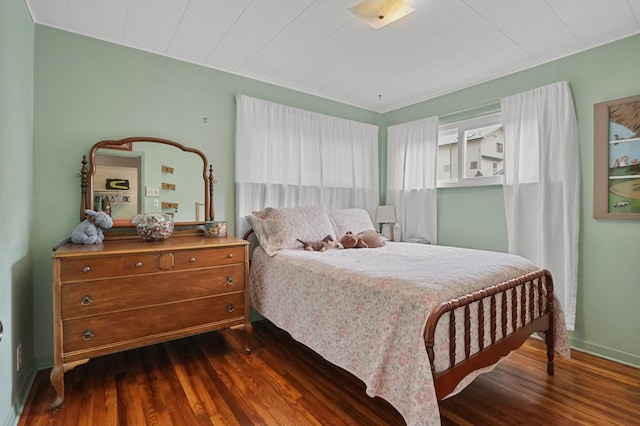 bedroom with baseboards and dark wood-style flooring