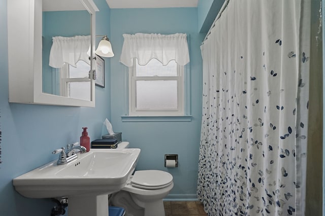 full bath featuring a sink, baseboards, toilet, and a shower with shower curtain