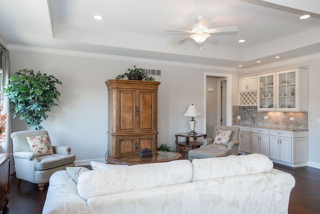 living area featuring recessed lighting, ornamental molding, a raised ceiling, and dark wood-style flooring