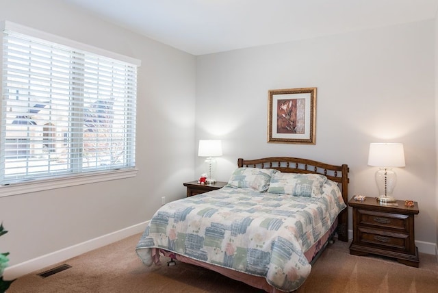 carpeted bedroom featuring visible vents and baseboards