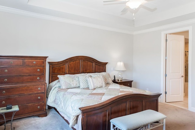 bedroom with ceiling fan, a tray ceiling, ornamental molding, and light carpet