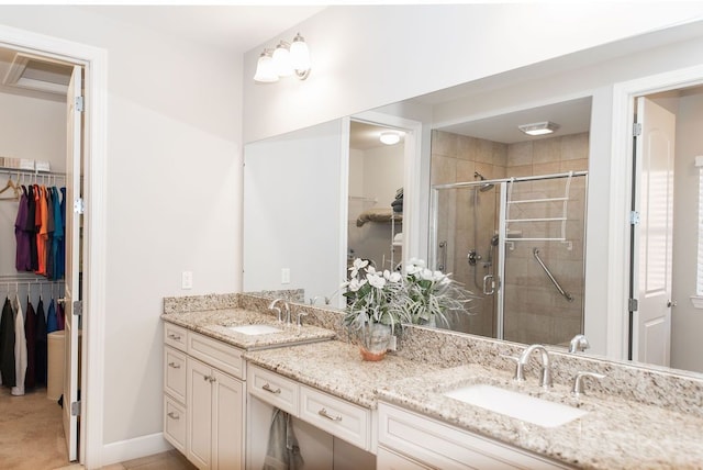 full bathroom with a sink, double vanity, a stall shower, and a spacious closet