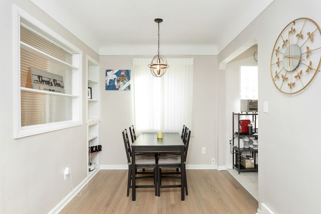 dining area with built in features, wood finished floors, and baseboards