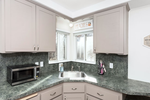 kitchen with stainless steel microwave, backsplash, and a sink