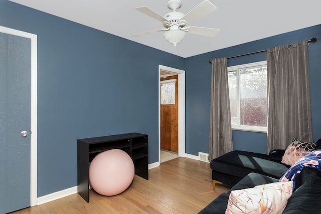 sitting room featuring visible vents, a ceiling fan, baseboards, and wood finished floors