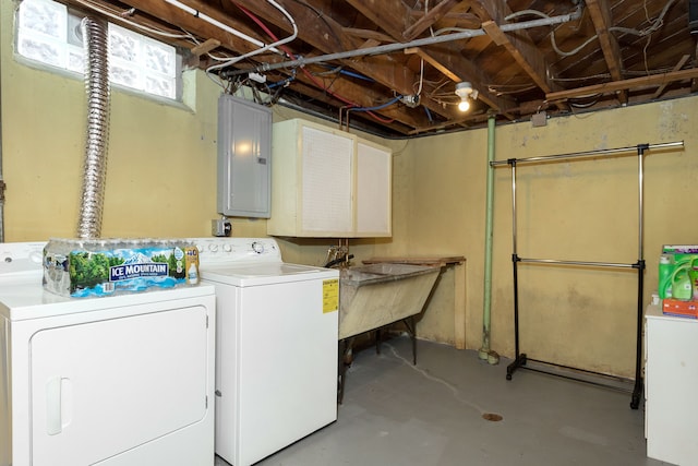 clothes washing area featuring laundry area, electric panel, separate washer and dryer, and a sink