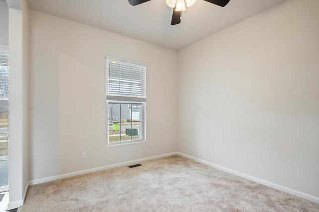 unfurnished room featuring visible vents, carpet flooring, a ceiling fan, and baseboards