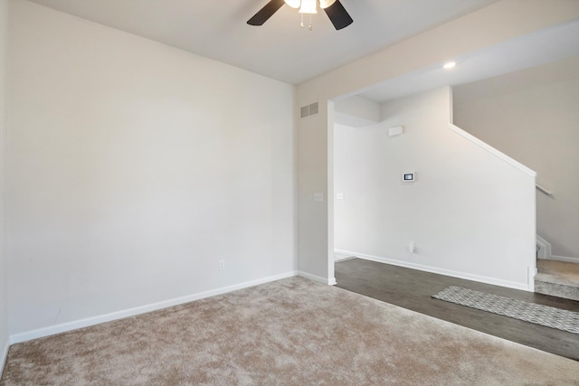 spare room featuring visible vents, baseboards, stairway, carpet flooring, and a ceiling fan