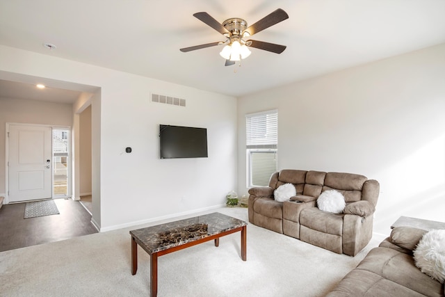 living area featuring a ceiling fan, carpet flooring, baseboards, and visible vents