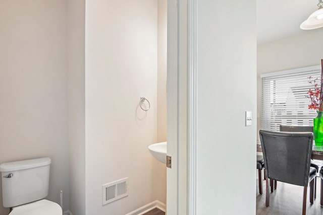 bathroom featuring visible vents, baseboards, and toilet