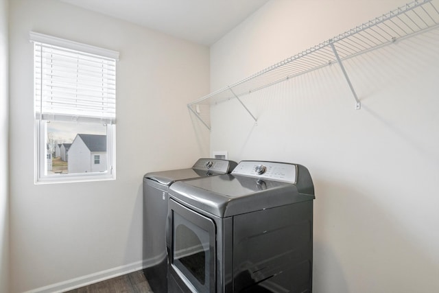 clothes washing area featuring washer and clothes dryer, laundry area, baseboards, and dark wood-style flooring