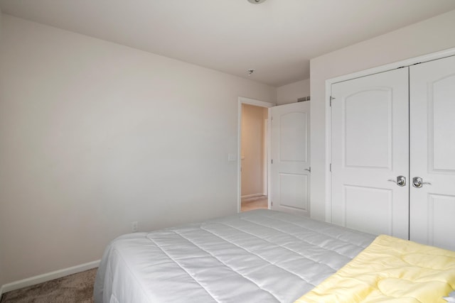 bedroom with a closet, baseboards, and carpet