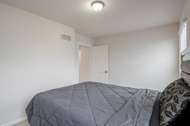 carpeted bedroom featuring visible vents and baseboards