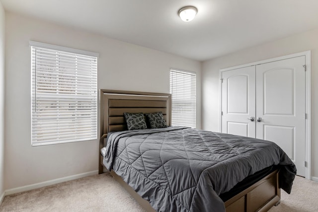 bedroom featuring a closet, baseboards, and carpet floors