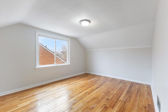 bonus room with vaulted ceiling, visible vents, baseboards, and wood-type flooring