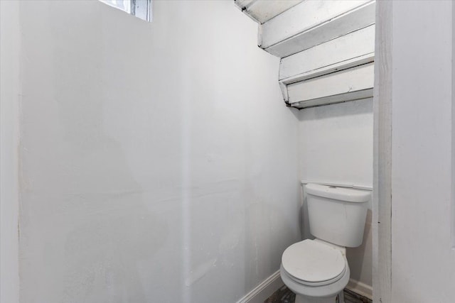 bathroom with toilet and baseboards