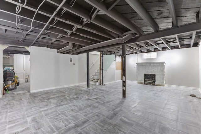 basement featuring stairway, baseboards, and a fireplace