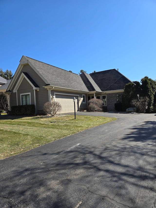 ranch-style house featuring a front lawn, a garage, and driveway