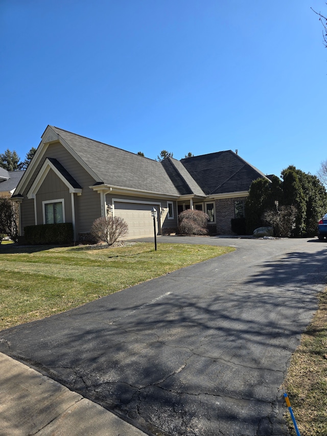 view of front of house with a front yard, a garage, and driveway