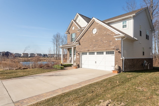 view of front facade featuring a water view, concrete driveway, brick siding, a garage, and a front yard