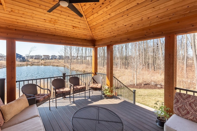 wooden deck with a ceiling fan and a water view
