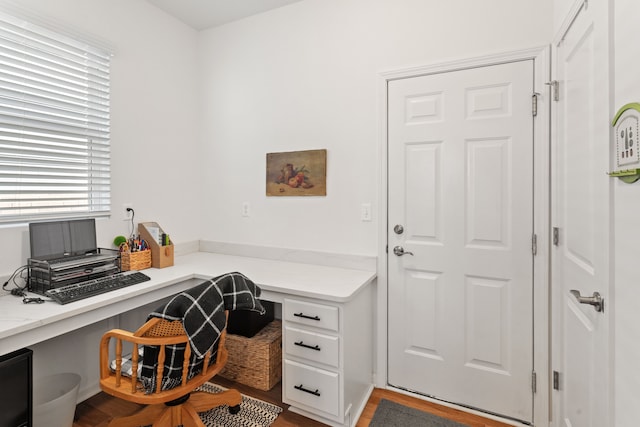 home office with wood finished floors and built in study area