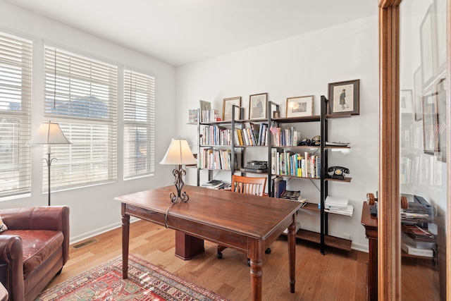 home office featuring baseboards, visible vents, and light wood-style floors