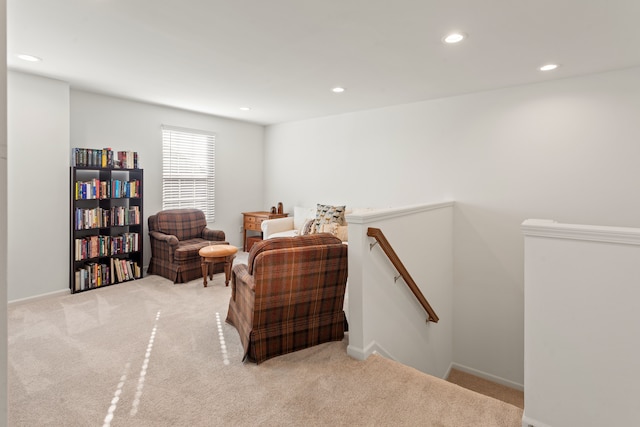 sitting room featuring baseboards, carpet floors, an upstairs landing, and recessed lighting