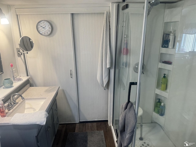 bathroom with vanity, wood finished floors, and a stall shower