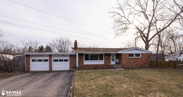 view of front of home featuring a front lawn, aphalt driveway, fence, an attached garage, and brick siding