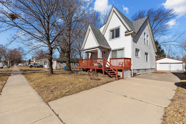 view of front of property featuring a deck, an outdoor structure, a detached garage, and a shingled roof