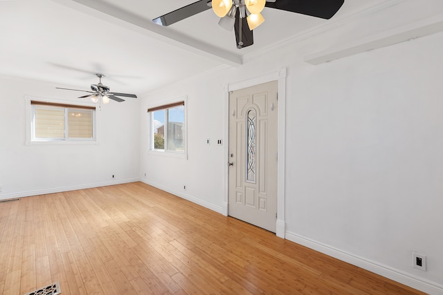 interior space featuring visible vents, baseboards, light wood-style floors, and ornamental molding