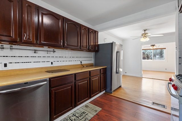 kitchen featuring tasteful backsplash, dark brown cabinetry, light countertops, appliances with stainless steel finishes, and wood finished floors