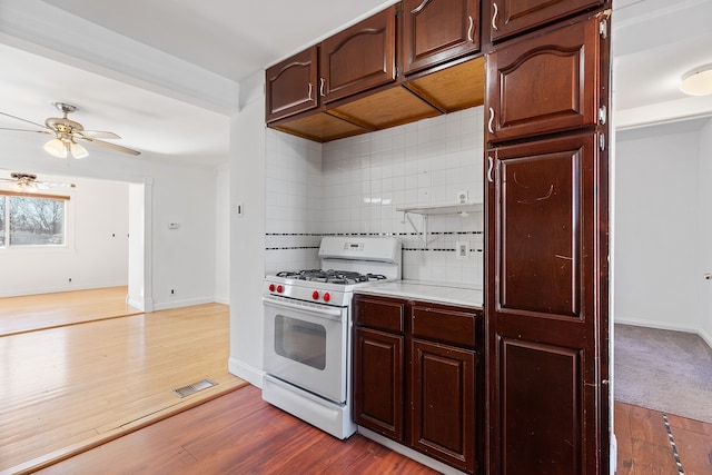 kitchen with light countertops, light wood-style flooring, and white gas range