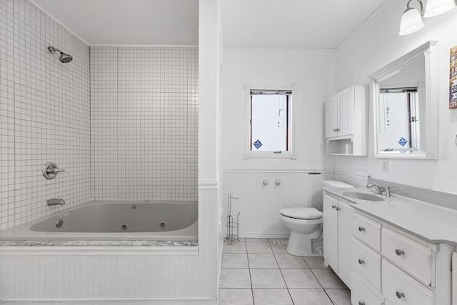 bathroom with a combined bath / shower with jetted tub, toilet, wainscoting, tile patterned floors, and vanity