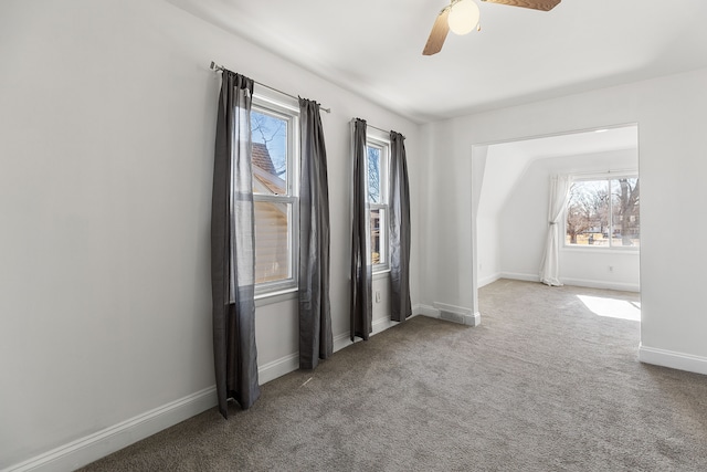 spare room with carpet flooring, baseboards, and ceiling fan