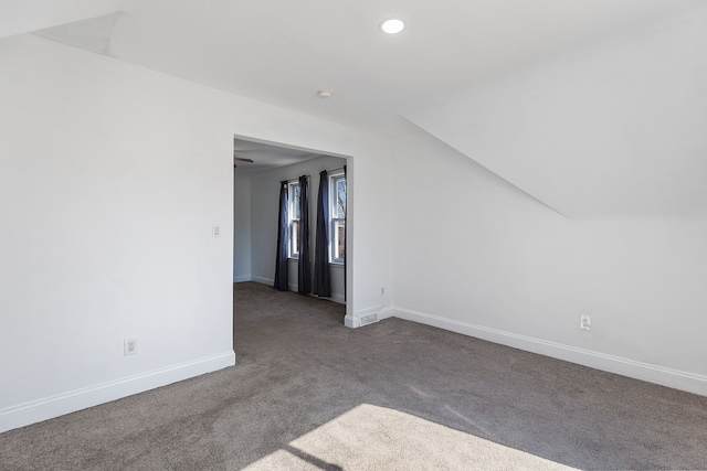 empty room featuring carpet flooring, recessed lighting, lofted ceiling, and baseboards