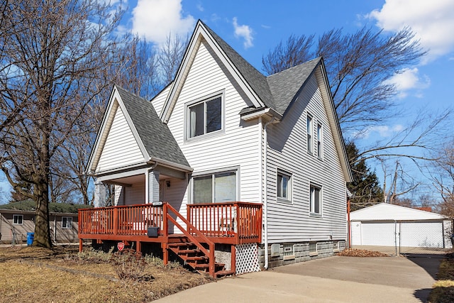 view of front of property featuring a garage, a wooden deck, an outdoor structure, and a shingled roof