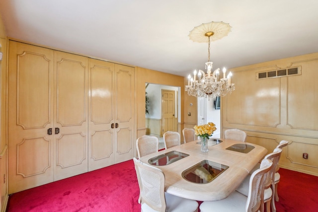 dining area featuring visible vents, a chandelier, and a decorative wall