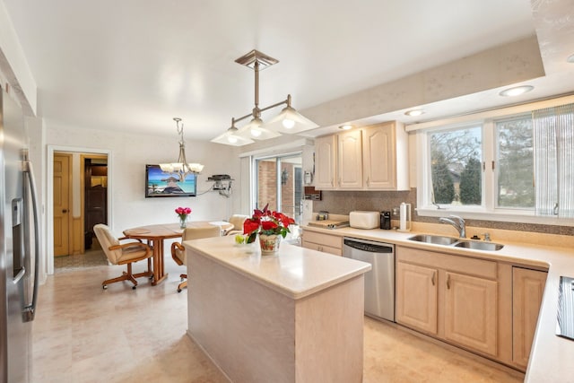 kitchen with light brown cabinetry, light countertops, appliances with stainless steel finishes, and a sink