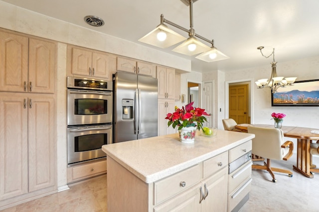 kitchen with visible vents, light brown cabinetry, a center island, stainless steel appliances, and hanging light fixtures