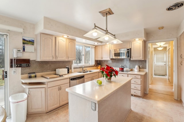 kitchen with a sink, light countertops, light brown cabinetry, and stainless steel appliances