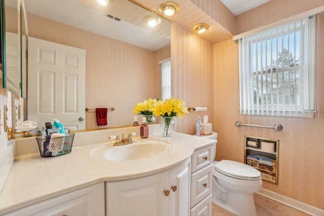 bathroom with visible vents, toilet, wallpapered walls, baseboards, and vanity