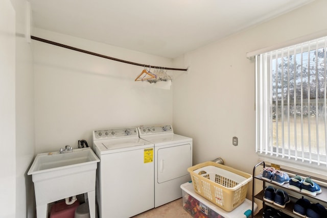 laundry room featuring laundry area, plenty of natural light, washing machine and dryer, and a sink