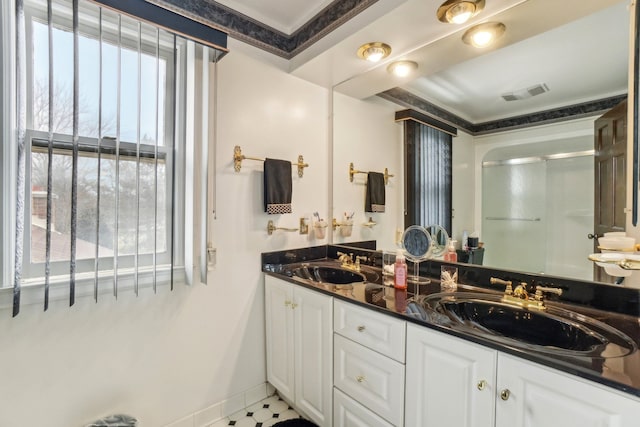 bathroom with a stall shower, visible vents, a wealth of natural light, and a sink