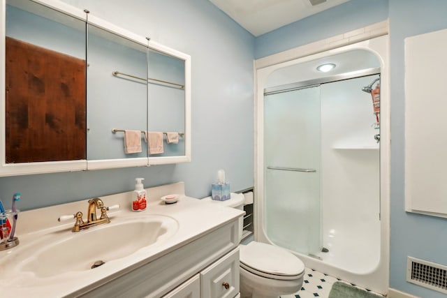 bathroom with visible vents, toilet, vanity, and a walk in shower