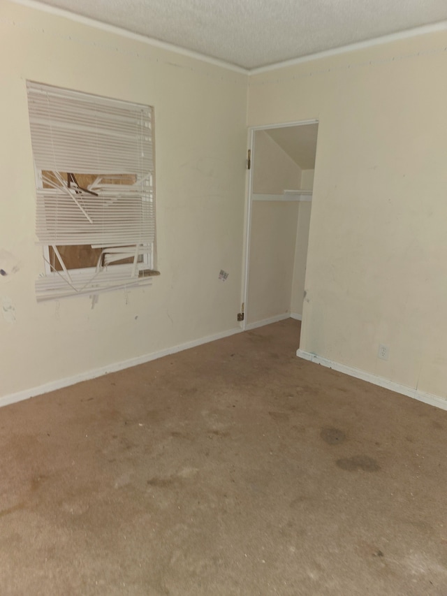 spare room featuring a textured ceiling and baseboards