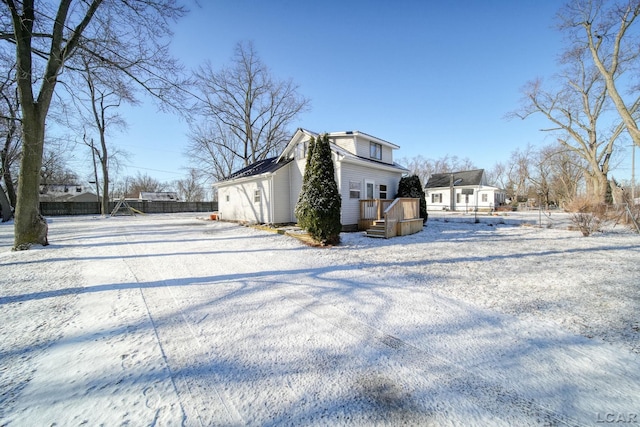 snow covered property with fence